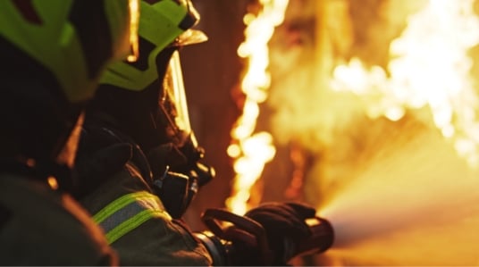 Image de pompiers qui luttent contre un incendie avec un tuyau d'eau