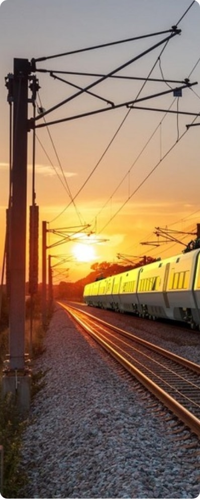 photo d'un train sur rail devant un couché de soleil